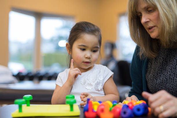 istock Occupational therapist works with a young ethnic girl 1157244308