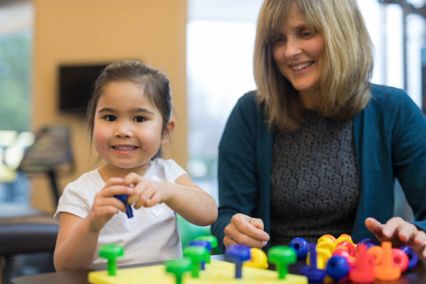 istock Occupational therapist works with a young ethnic girl 1157244314