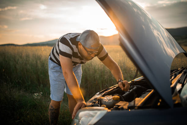istock Man fixing car on a country road in sunset 1157246287