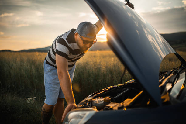 istock Man fixing car on a country road in sunset 1157247058