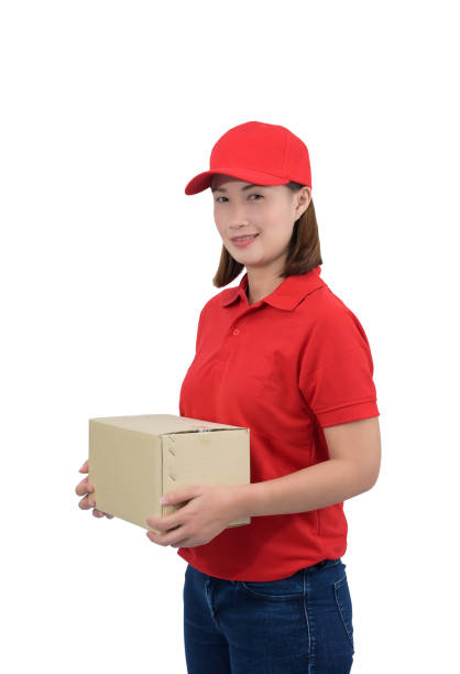 istock Smiling delivery woman in red uniform giving parcel boxes, isolated on white background 1157256435