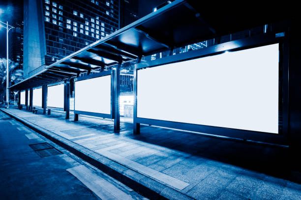 blank billboards at bus stop at night stock photo