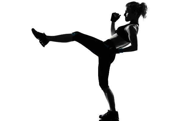 woman workout high kick posture one woman exercising workout fitness aerobic exercise posture  in studio   on white background fighting stance stock pictures, royalty-free photos & images