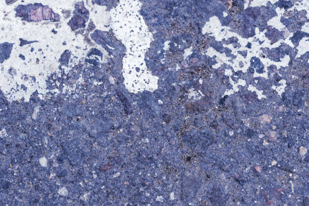 istock White paint on the old asphalt surface close up. Blue color abstract background 1157266645