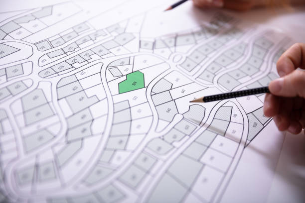 Human Hand Holding Pencil Over Cadastre Map Close-up Of Human Hand Holding Pencil Over Paper Cadastre Map land planning stock pictures, royalty-free photos & images