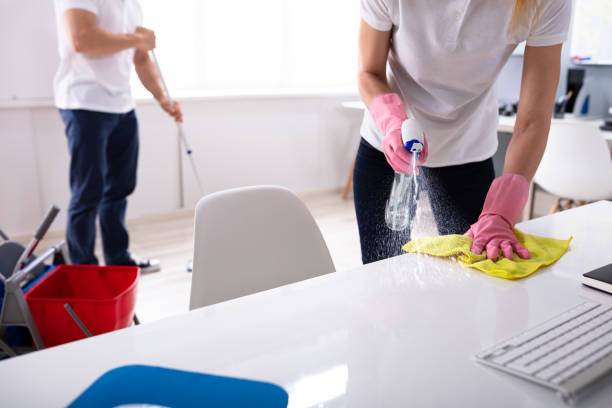 Two Young Janitor Cleaning The Office Two Janitor Cleaning The Desk And Mopping Floor In The Office sweeping photos stock pictures, royalty-free photos & images