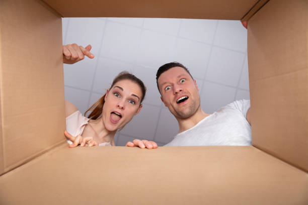 istock Happy Couple Looking Inside Cardboard Box 1157269355