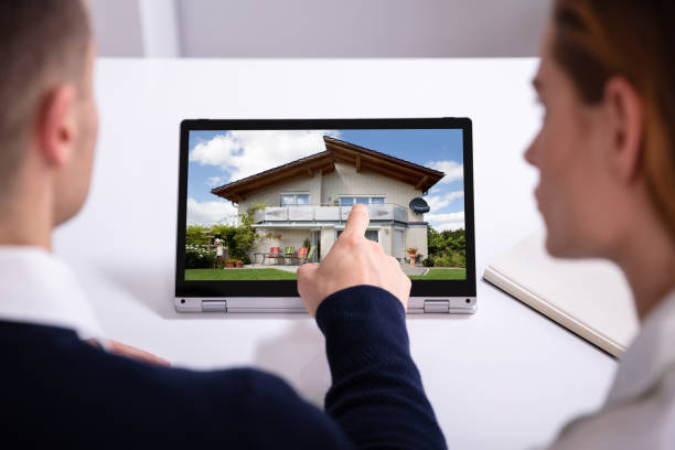 istock Estate Agent's Hand Pointing Laptop Screen Showing House Model 1157269664