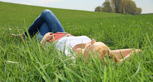 istock Attractive woman lying in the grass 115726987