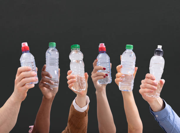 istock Different People Holding Water Bottles In A Row 1157270463