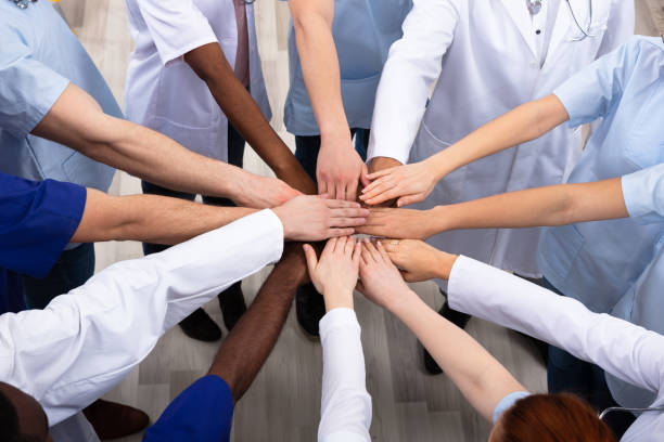 Elevated View Of Doctors Stacking Hands Directly Above Shot Of Medical Team Stacking Hands Together At Hospital stacked hands photos stock pictures, royalty-free photos & images