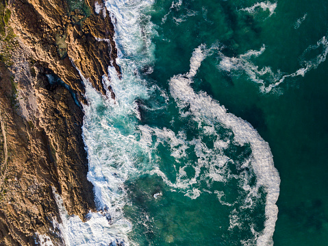 Aerial view of beautiful seascape. Waves are crashing on rocky coastline. Scenic view of ocean.