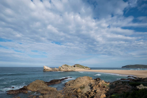 istock Waves crashing on rocky coastline against sky 1157270752