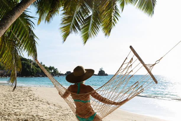 istock Woman In Bikini Sitting On Hammock On The Beach 1157270921