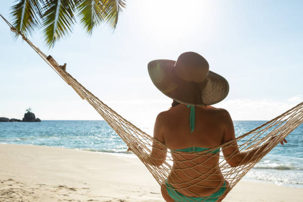 istock Woman In Bikini Sitting On Hammock On The Beach 1157270931