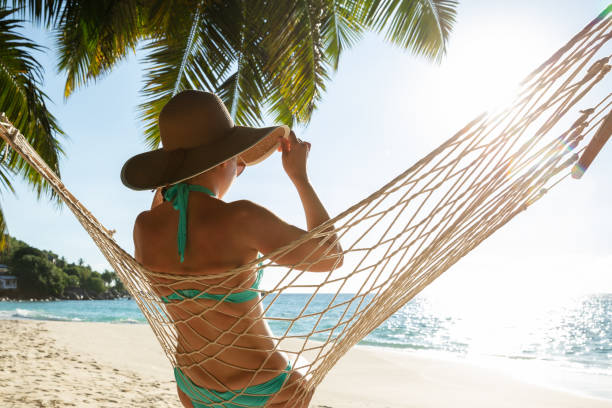 istock Woman In Bikini Sitting On Hammock On The Beach 1157270935