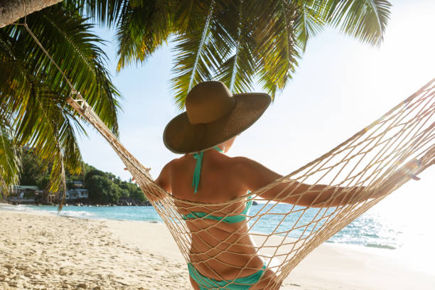 istock Woman In Bikini Sitting On Hammock On The Beach 1157270937