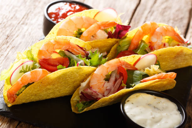 istock Fresh corn tacos with shrimps, fresh vegetables and sauces close-up. horizontal 1157273986