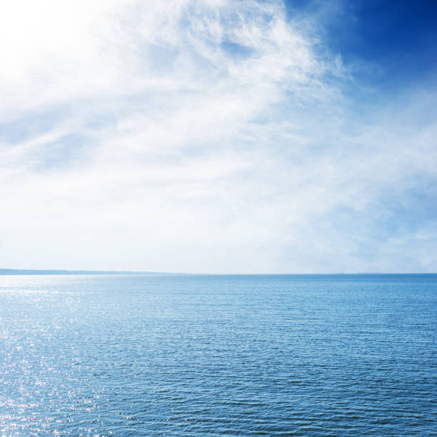 istock blue sea and sky with sun in clouds 1157284482