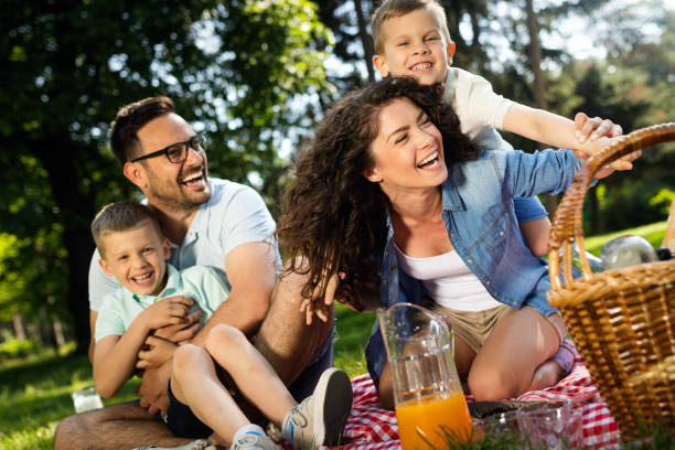 Cheerful happy family picnicking on a beautiful day Cheerful happy family picnicking on a beautiful day in a park picnic photos stock pictures, royalty-free photos & images