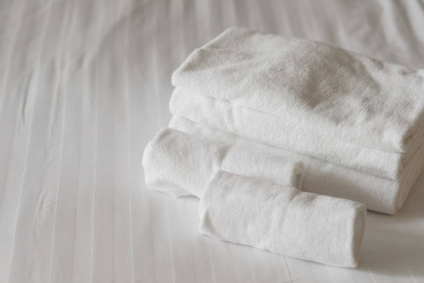 istock white fluffy towels on bed in hotel bedroom. Close up view 1157286921