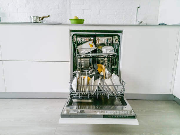 istock Open dishwasher with clean dishes in the white kitchen 1157288593