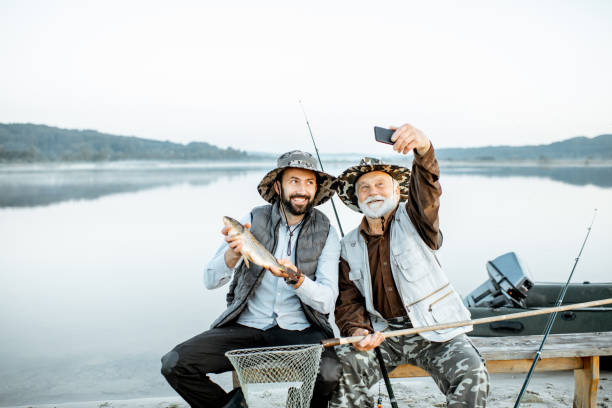 grand-père avec la pêche de fils sur le lac - fishing lake grandfather grandson photos et images de collection