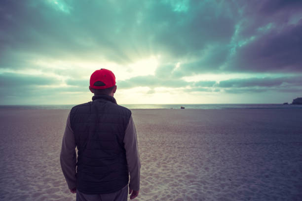 istock Silhouette of a man standing on the beach and looking 1157290343