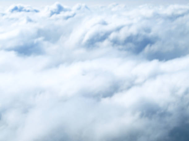 Blurred image of the clouds shoot from the top out of the airplane window. stock photo