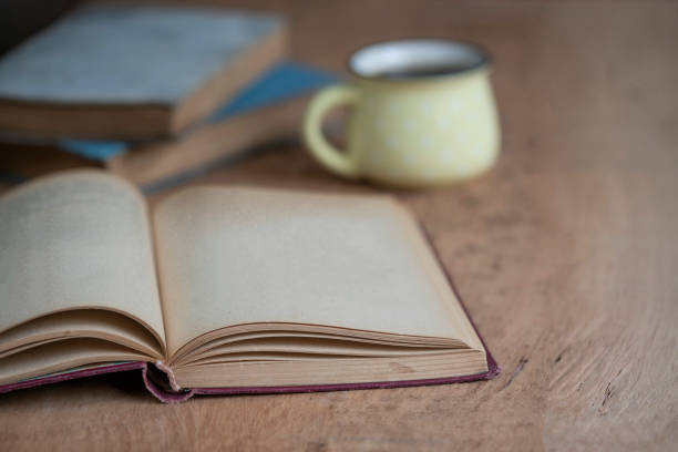 istock a cup of coffee and old books on table with copy space 1157292983