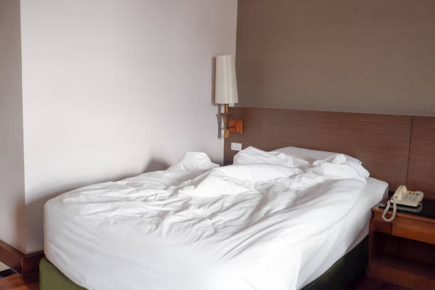 Unmade bed with messy stuff.