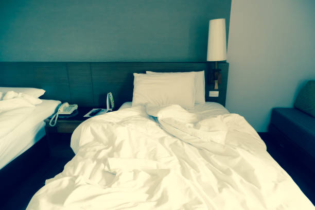 istock White crumpled bed sheet and two messy pillows in a hotel room. 1157294692