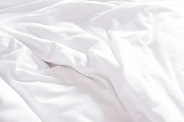 istock White crumpled bed sheet in a hotel room. 1157294709