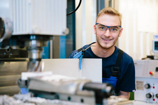 portrait: young technician with protective eyewear works at a milling machine - trainee mechanic engineer student imagens e fotografias de stock