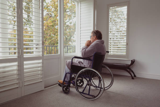 istock Disabled active senior man looking through window on wheelchair in a comfortable home 1157298147