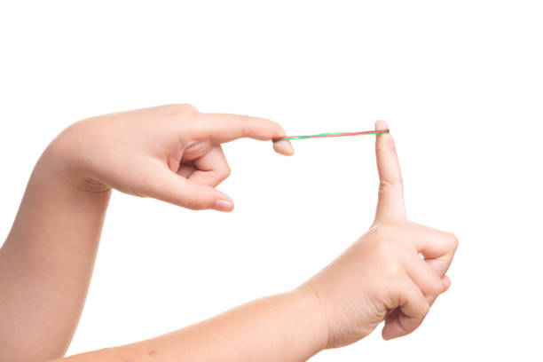 istock Child hand playing with elastic rubber band isolated on white 1157299049