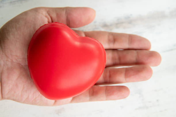 istock hands holding red rubber heart, love and care concept 1157305294