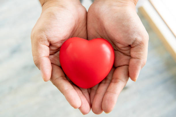 istock hands holding red rubber heart, love and care concept 1157305302