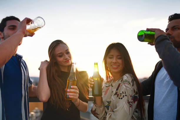 istock happy young people drinking beer on the roof 1157306061
