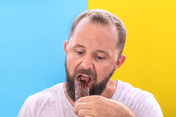 istock Diet and the problem of choice. Funny beard man doubts to eat an eclair 1157306653
