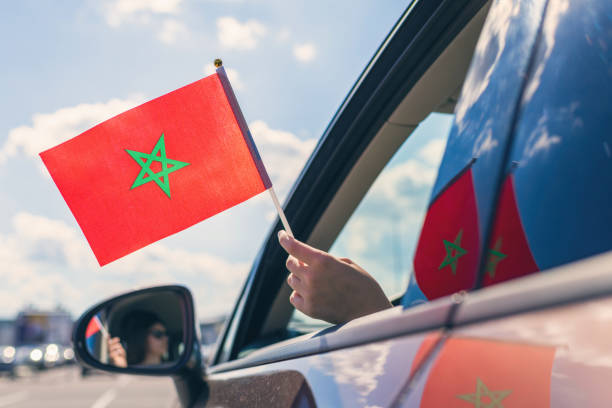 mujer o chica sosteniendo la bandera de marruecos desde la ventana abierta del coche - women open traditional culture human hand fotografías e imágenes de stock