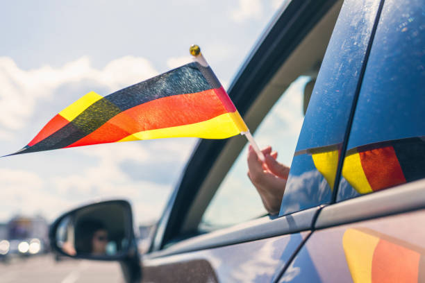 Woman or Girl Holding Germany Flag from the open car window. Concept stock photo