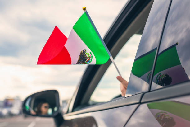 Woman or Girl Holding Mexican Flag from the open car window. Concept stock photo