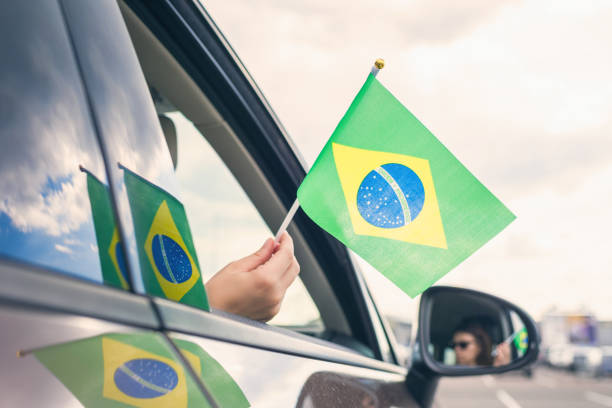 열린 차 창에서 브라질의 국기를 들고 여자 또는 소녀. 개념 - women open traditional culture human hand 뉴스 사진 이미지