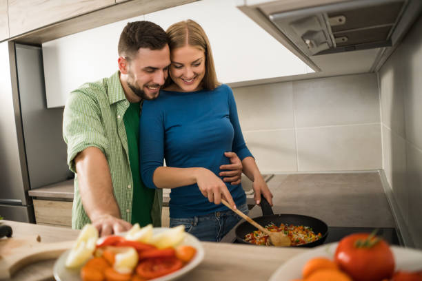 istock Couple making meal in their kitchen 1157312124