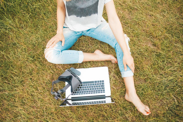 istock Top view of a blogger working in a park and using computer and 3D goggles 1157312960