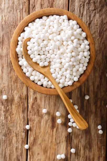 istock Organic tapioca pearls close-up in a bowl on a table. Vertical top view from above 1157315823