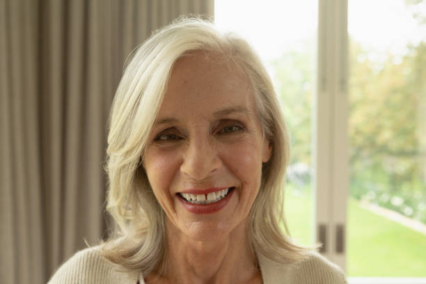 istock Active senior woman looking at camera in a comfortable home 1157316620