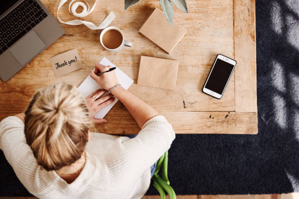 istock Overhead Shot Looking Down On Woman Writing In Generic Thank You Card 1157317607