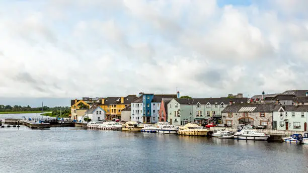 View of the river Shannon with boats anchored on the coast and the town of Athlone with picturesque houses, wonderful and relaxed day in the county of Westmeath, Ireland